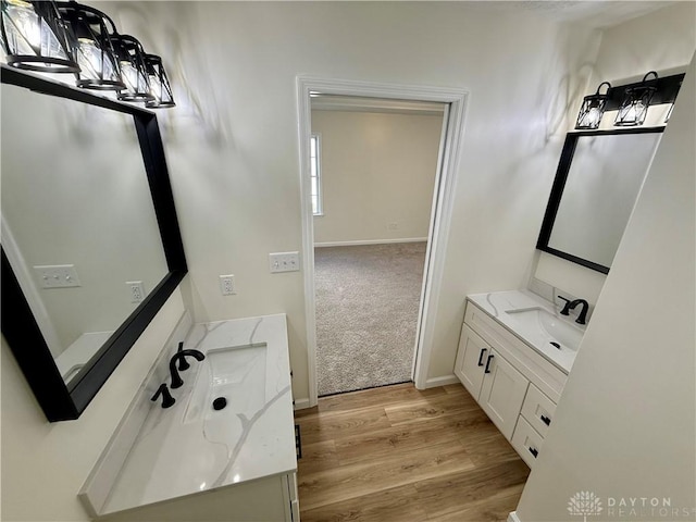 bathroom with baseboards, wood finished floors, and vanity