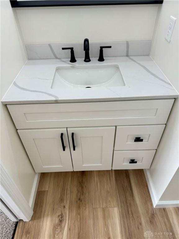 bathroom featuring vanity, baseboards, and wood finished floors