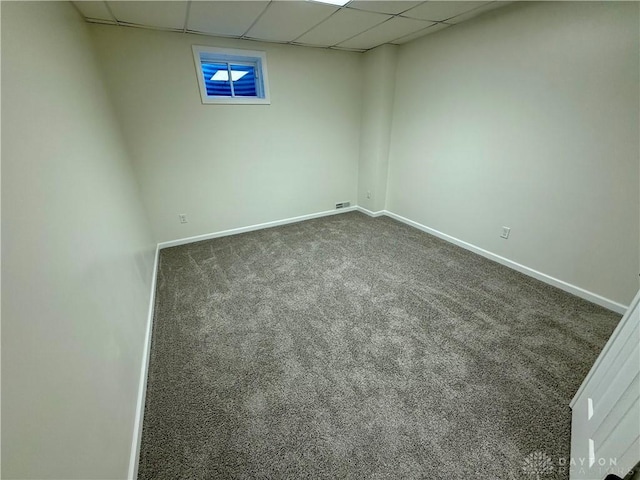 finished basement with a drop ceiling, carpet flooring, and baseboards