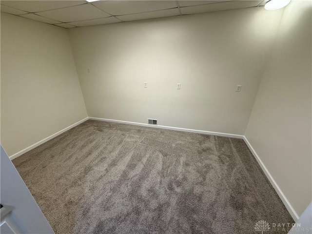 unfurnished room with a paneled ceiling, baseboards, visible vents, and carpet flooring