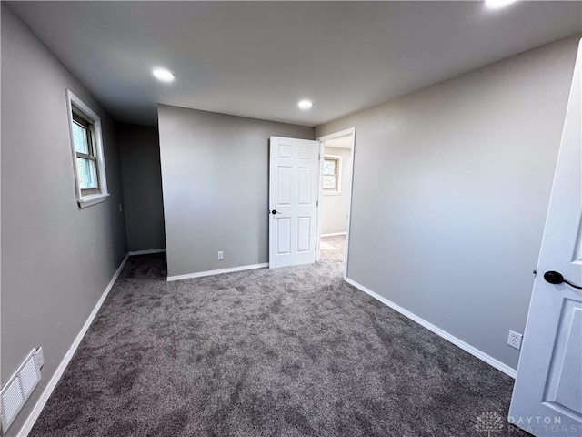 unfurnished bedroom with carpet, visible vents, baseboards, and recessed lighting