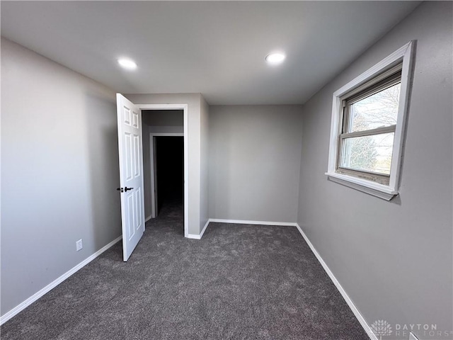 interior space featuring baseboards, dark colored carpet, and recessed lighting