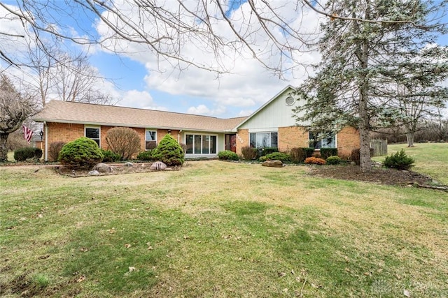 single story home featuring a front yard and brick siding