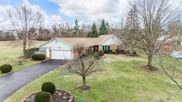 ranch-style house with a garage, aphalt driveway, and a front lawn