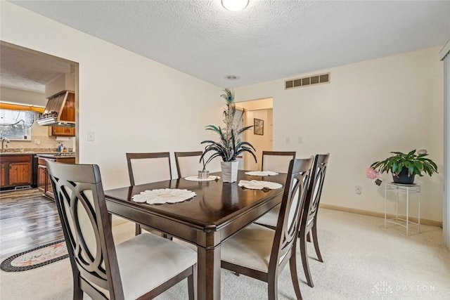 dining area featuring a textured ceiling, visible vents, and baseboards