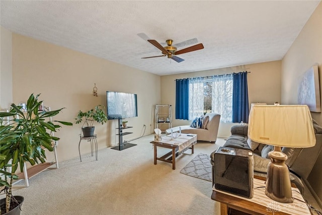 carpeted living area featuring ceiling fan and a textured ceiling