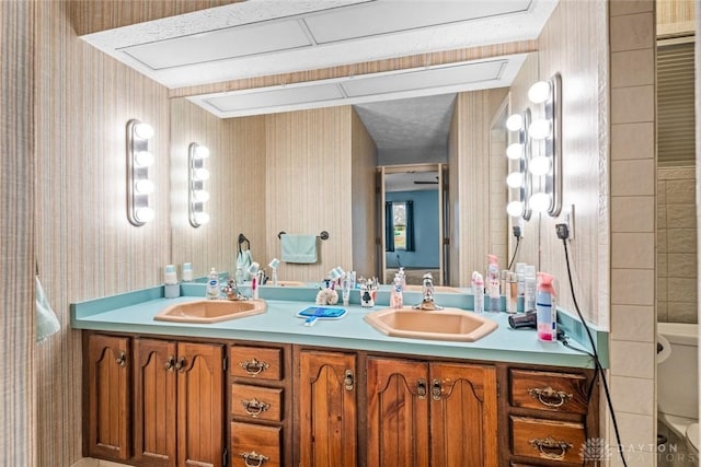 full bath featuring a sink, toilet, and double vanity