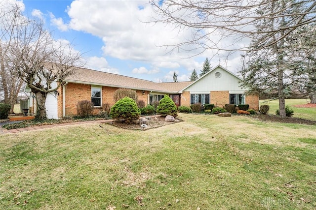 single story home with a front yard, brick siding, and an attached garage