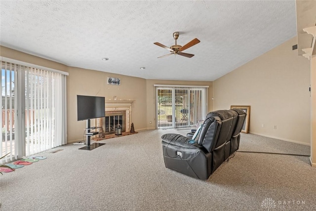 carpeted living area with baseboards, a wealth of natural light, and a glass covered fireplace