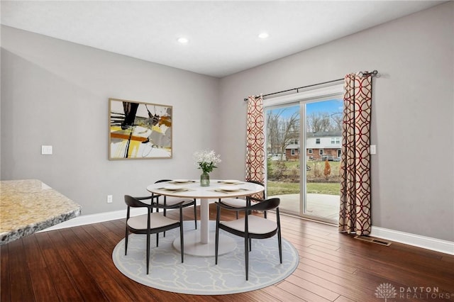 dining room featuring baseboards, hardwood / wood-style floors, and recessed lighting