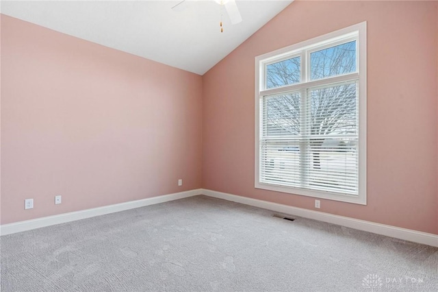 empty room with visible vents, baseboards, ceiling fan, carpet, and vaulted ceiling