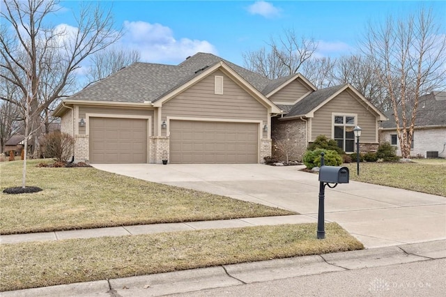 single story home featuring a garage, concrete driveway, a front lawn, and brick siding