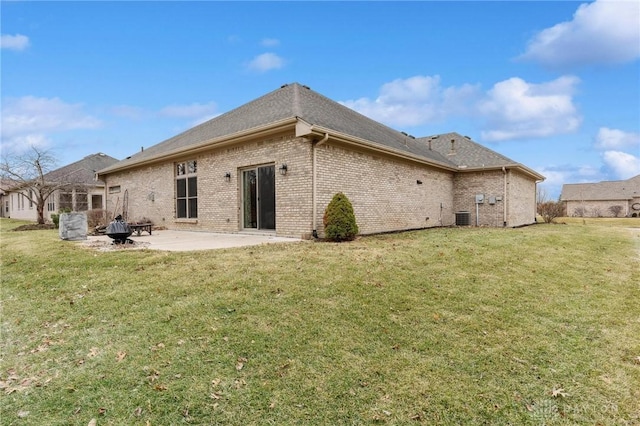 back of house featuring brick siding, a yard, central AC unit, and a patio