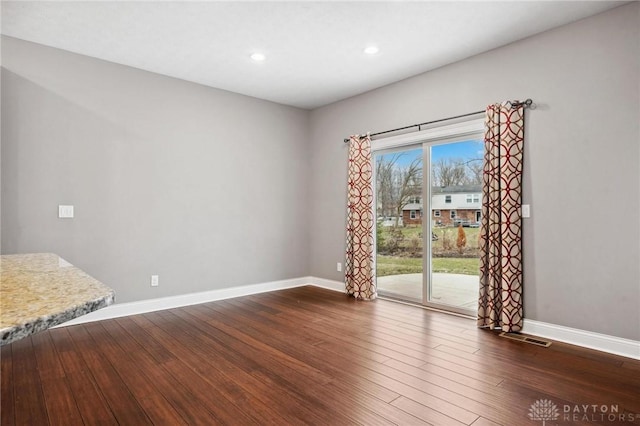 interior space featuring dark wood-style flooring, recessed lighting, visible vents, and baseboards