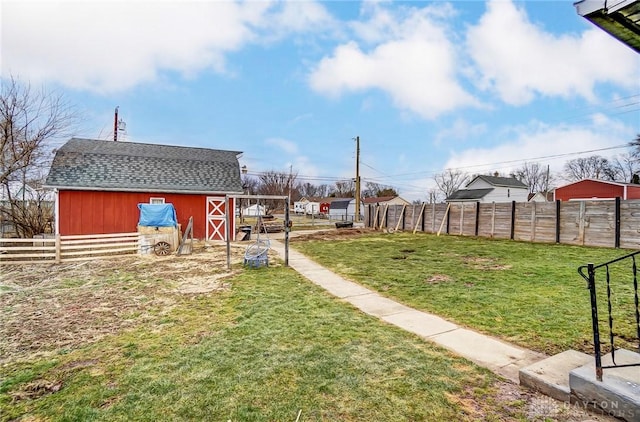 view of yard with an outbuilding, fence, and a barn