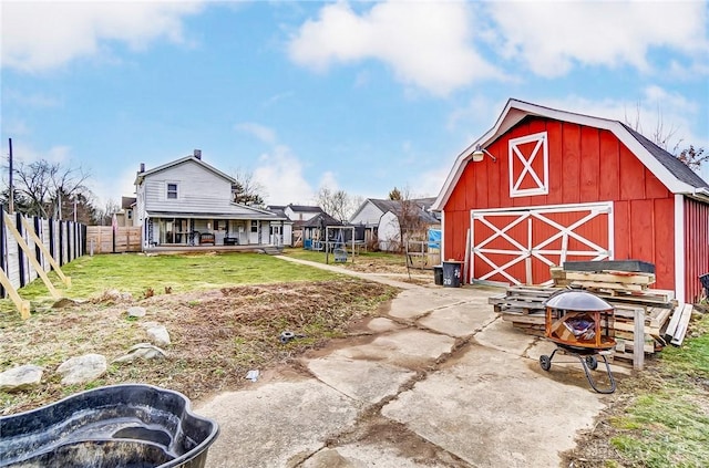 view of yard featuring an outbuilding, fence, and a barn