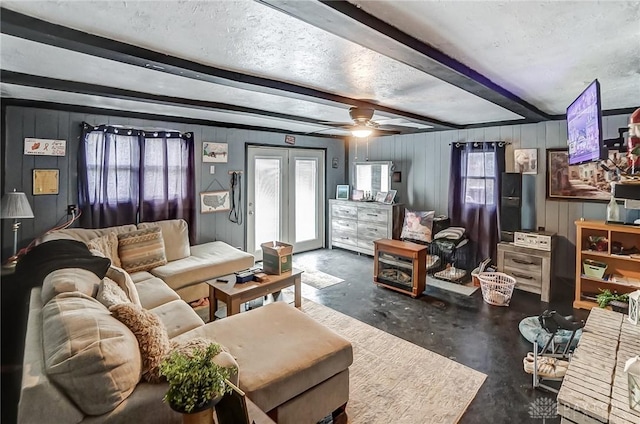 living room featuring a wealth of natural light, ceiling fan, concrete flooring, and beam ceiling