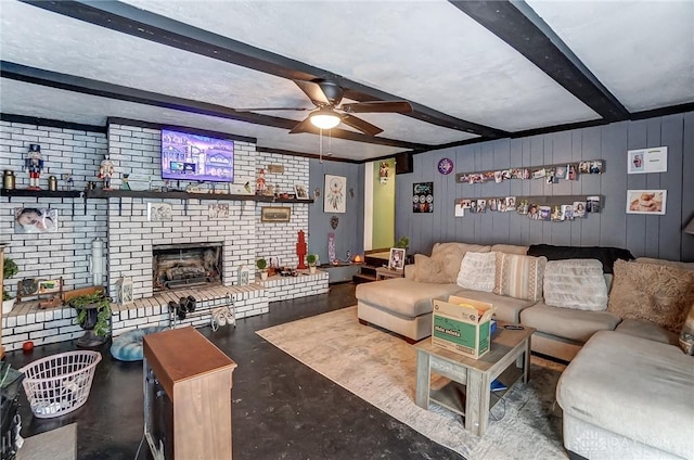 living area with brick wall, a fireplace, a ceiling fan, finished concrete flooring, and beamed ceiling