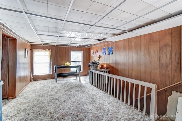 interior space with carpet flooring and wooden walls