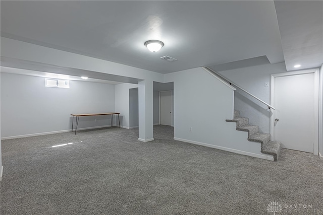 below grade area with stairway, carpet, visible vents, and baseboards