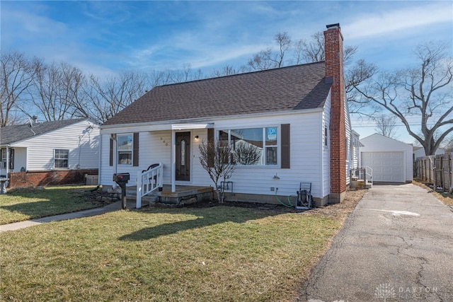 bungalow-style house featuring a shingled roof, a chimney, a detached garage, an outdoor structure, and a front yard