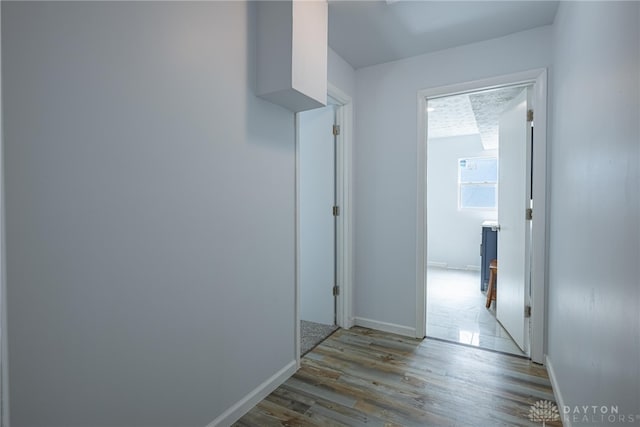 hallway featuring baseboards and wood finished floors