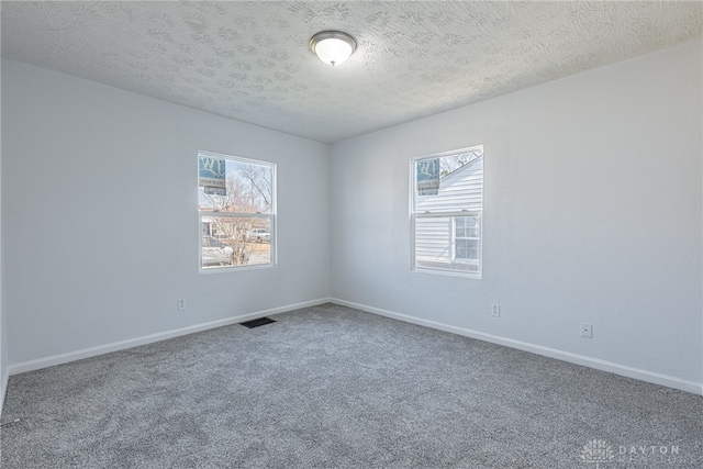 unfurnished room with carpet floors, a textured ceiling, and baseboards