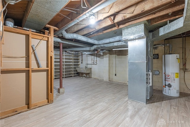 unfinished below grade area featuring heating unit, a sink, gas water heater, and wood finished floors