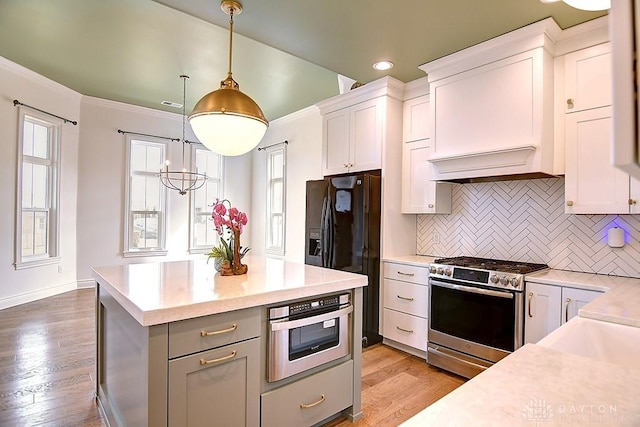9471 Banyan Ct, Dayton, OH 45458 - kitchen with light wood-style flooring, black refrigerator with ice dispenser, light countertops, stainless steel range with gas cooktop, and white cabinetry