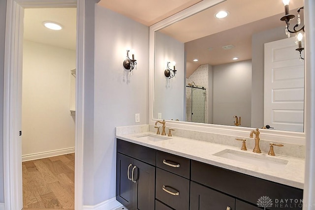 9471 Banyan Ct, Dayton, OH 45458 - bathroom with double vanity, wood finished floors, a stall shower, and a sink