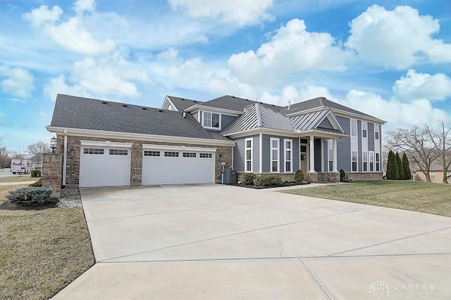 view of front of property with an attached garage, central air condition unit, brick siding, concrete driveway, and a front yard