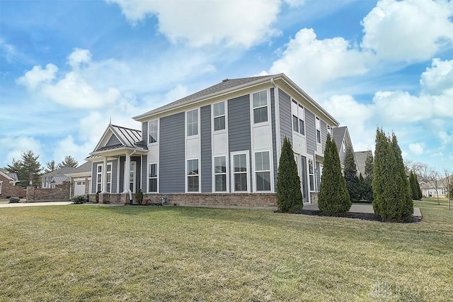 colonial home with a standing seam roof, metal roof, a front lawn, and brick siding