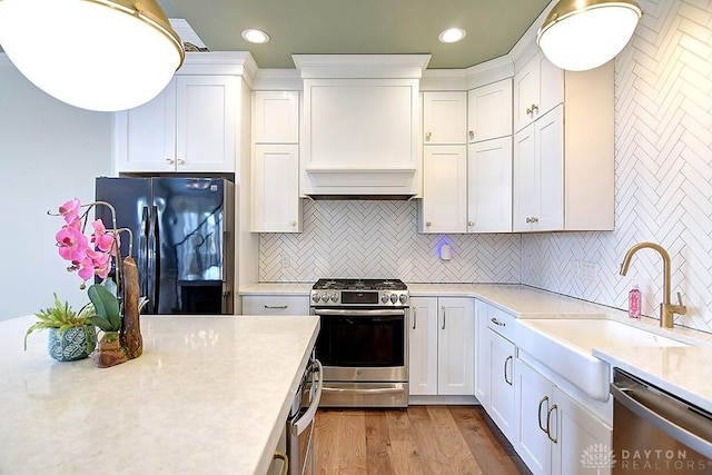 9471 Banyan Ct, Dayton, OH 45458 - kitchen with a sink, white cabinets, light countertops, appliances with stainless steel finishes, and custom exhaust hood