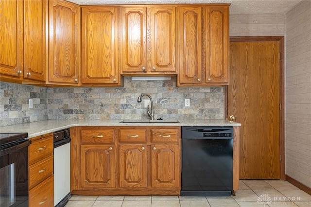 kitchen featuring black appliances, brown cabinets, a sink, and light countertops