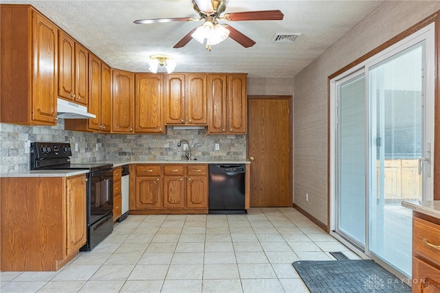 kitchen with under cabinet range hood, a sink, light countertops, brown cabinets, and black appliances