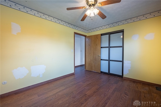 unfurnished room featuring visible vents, baseboards, ceiling fan, wood finished floors, and a textured ceiling