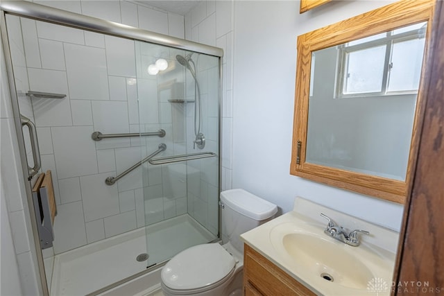 bathroom featuring a stall shower, vanity, and toilet