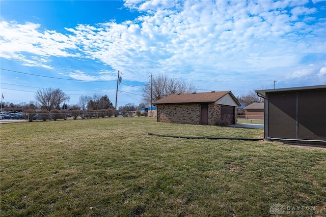 view of yard featuring a sunroom and a detached garage