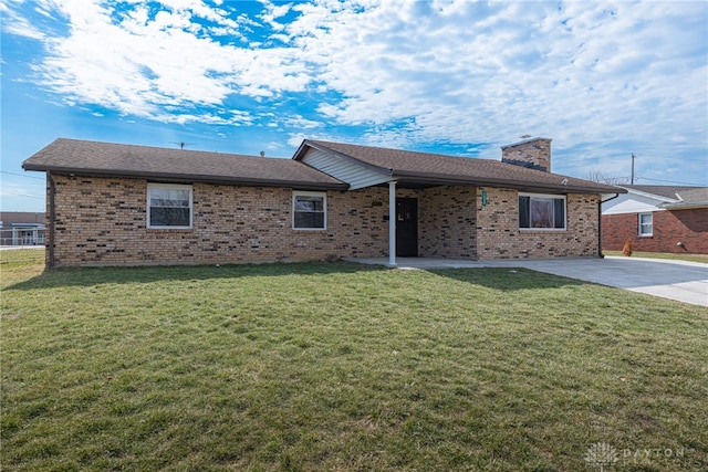 ranch-style home featuring a patio, brick siding, a chimney, and a front lawn