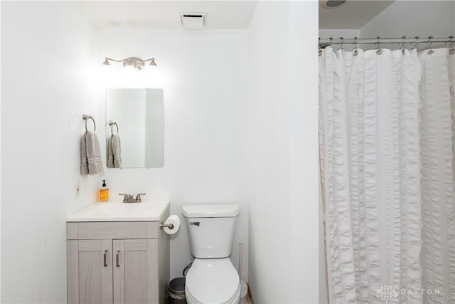 full bathroom featuring a shower with shower curtain, visible vents, vanity, and toilet