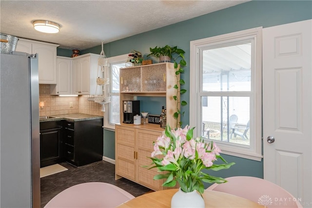 kitchen featuring white cabinetry, light countertops, a wealth of natural light, and freestanding refrigerator