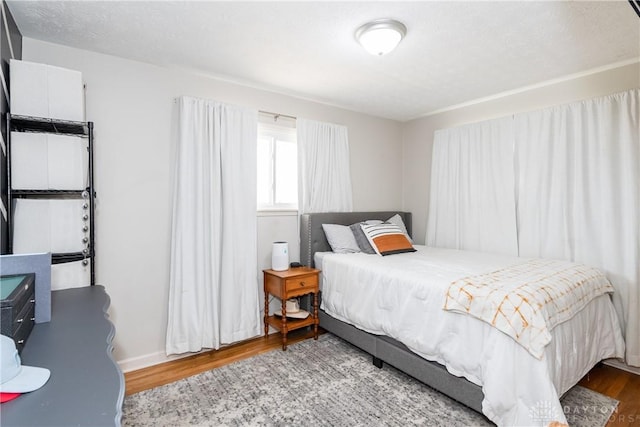 bedroom featuring a textured ceiling and wood finished floors