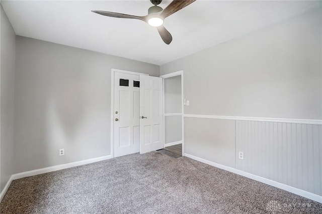 unfurnished bedroom featuring carpet, baseboards, and a ceiling fan