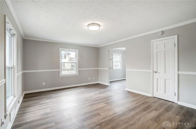 unfurnished room with ornamental molding, baseboards, and wood finished floors