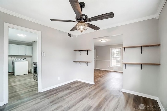 unfurnished living room with washer / dryer, light wood-type flooring, and ornamental molding