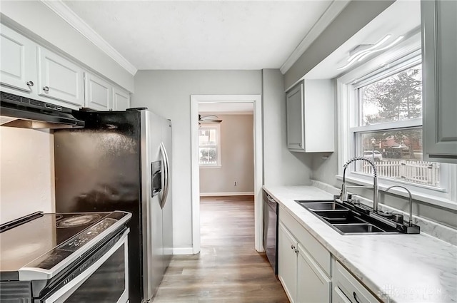 kitchen featuring electric stove, light wood-style floors, a sink, dishwasher, and under cabinet range hood