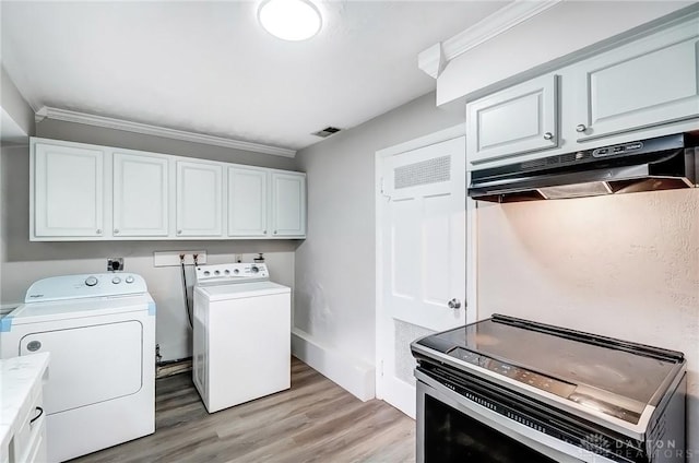 laundry room with washing machine and clothes dryer, visible vents, cabinet space, light wood-style flooring, and ornamental molding