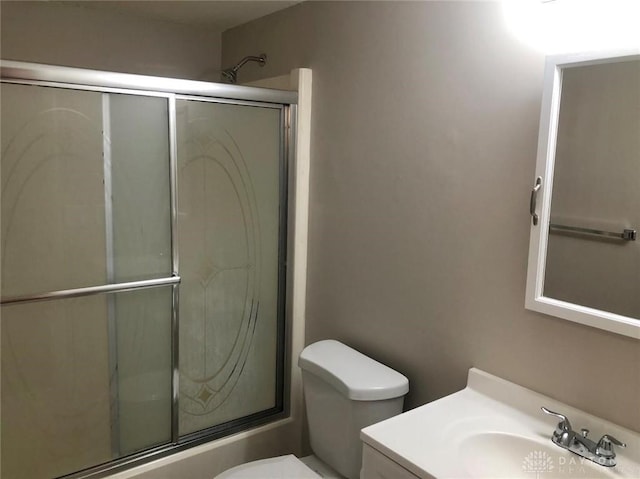 full bathroom featuring vanity, an enclosed shower, and toilet