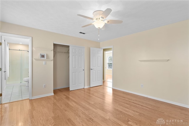 unfurnished bedroom with light wood-style floors, visible vents, baseboards, and a closet