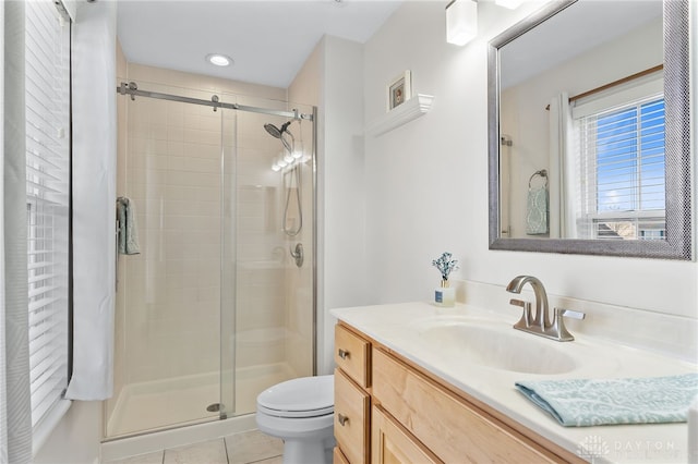 full bath featuring a stall shower, tile patterned flooring, vanity, and toilet